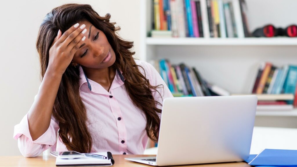 Woman in front of computer is stressed because DIY SEO is difficult.